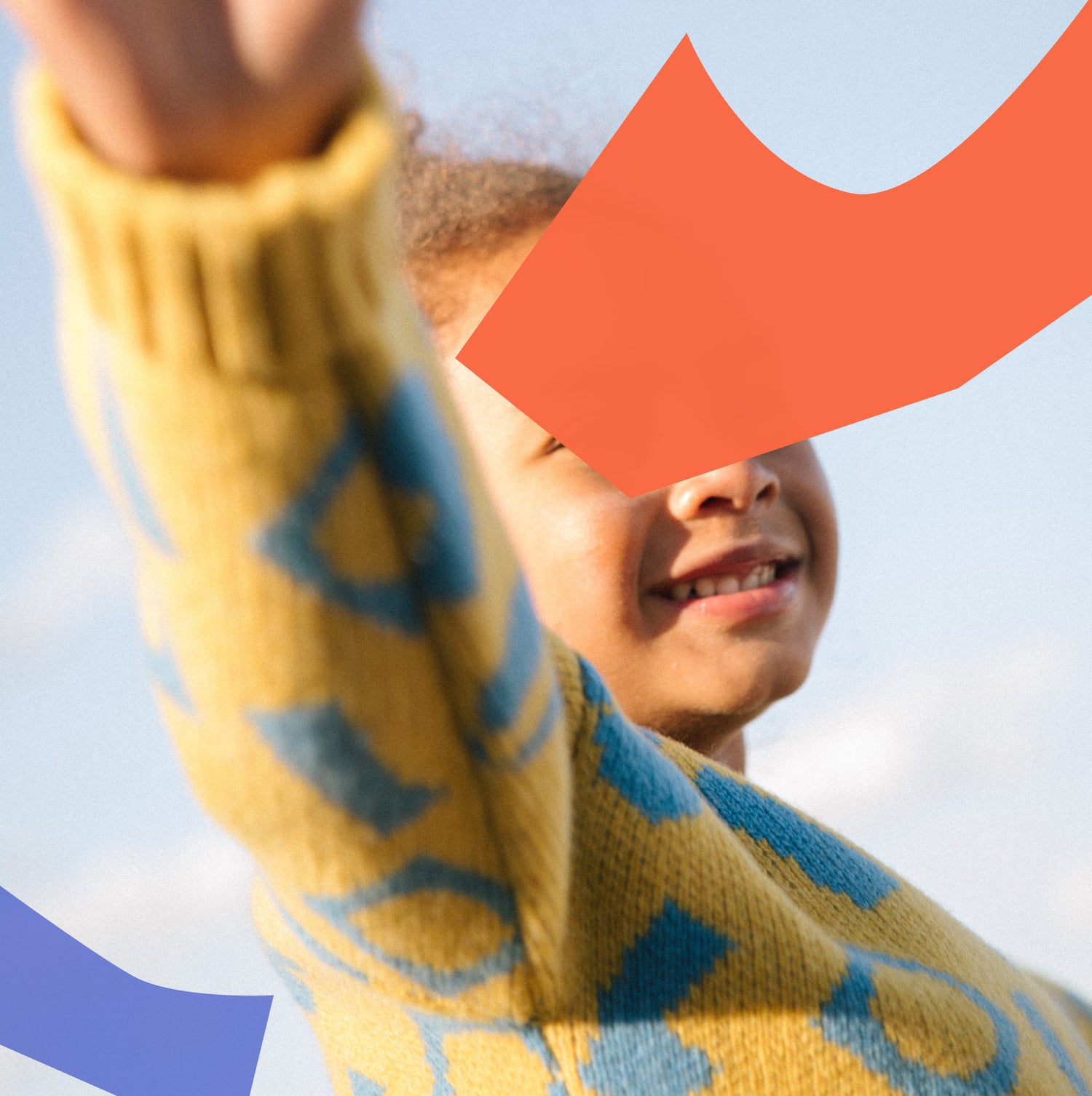 Child wearing blue and yellow jacquard jumper with fold back cuff in wool.