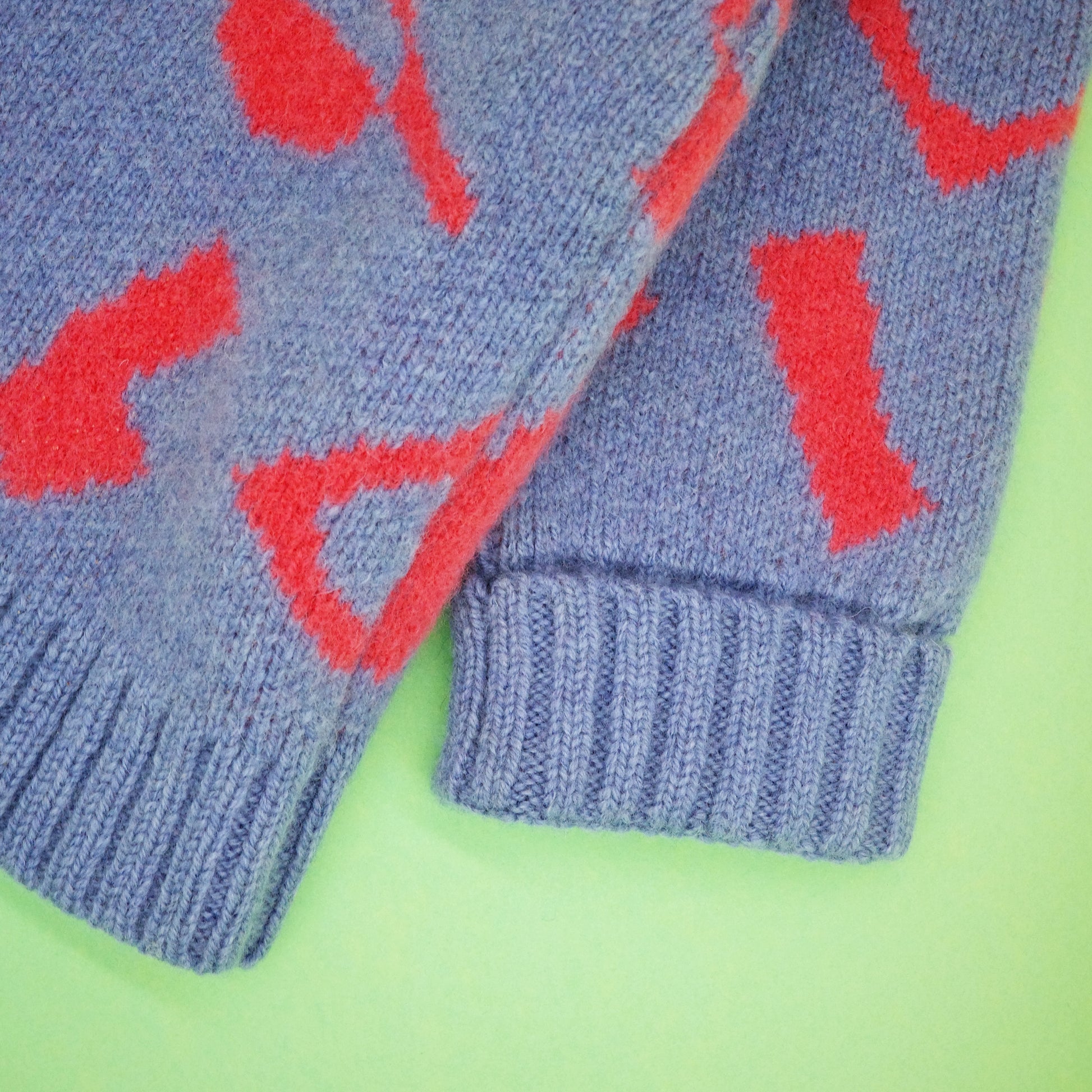 Fold back cuff of children's blue and coral knit jumper.