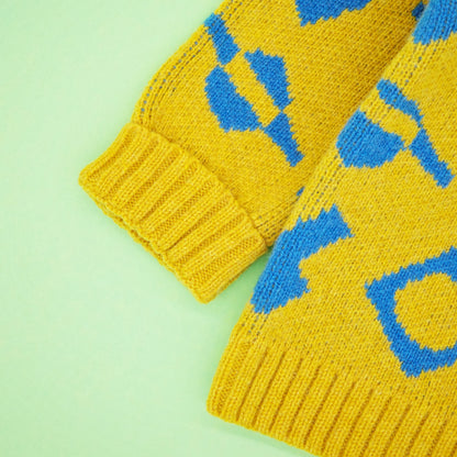 Fold back cuff of children's wool cardigan, in a yellow and blue jacquard.