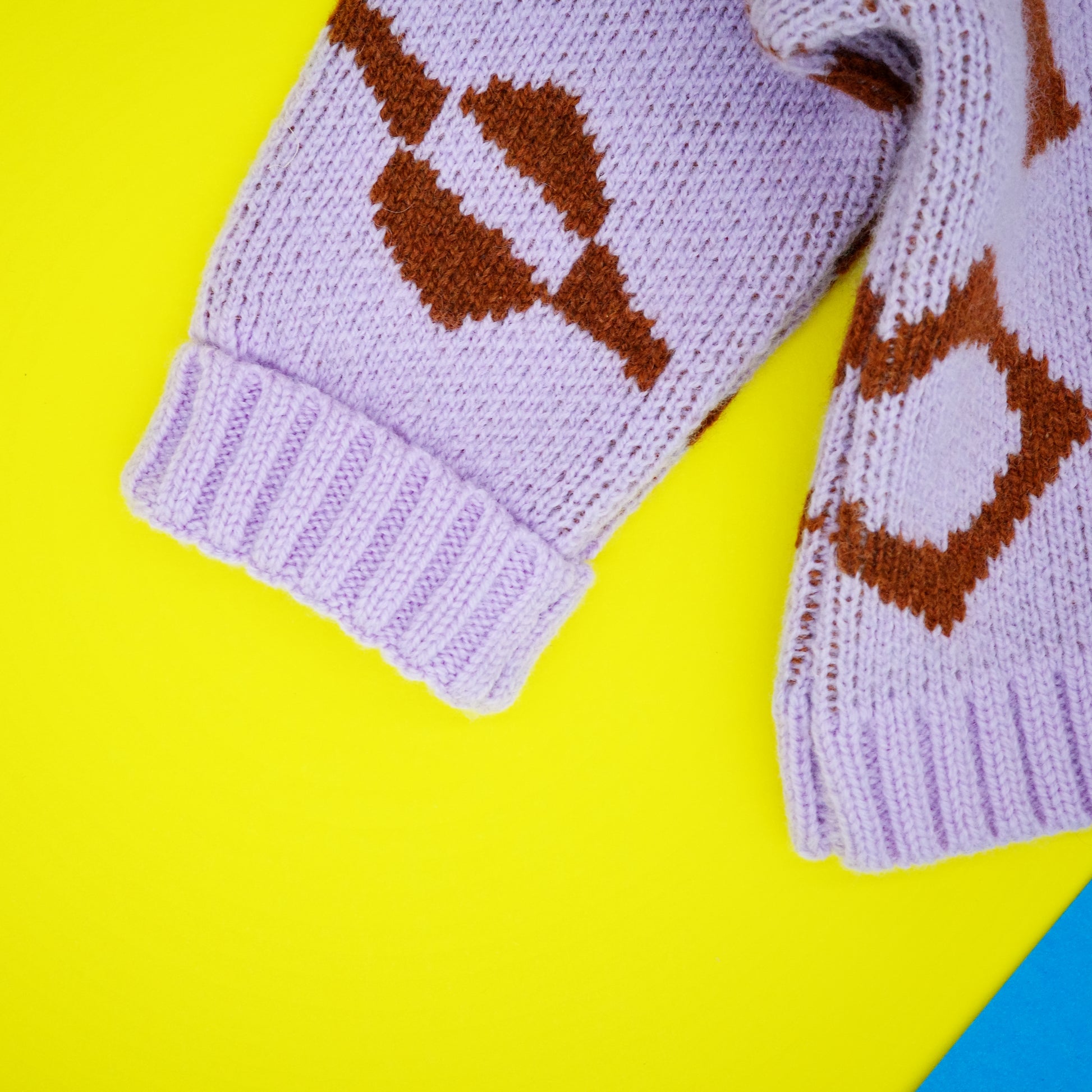 Fold back cuff on lilac and brown knitted children's cardigan.