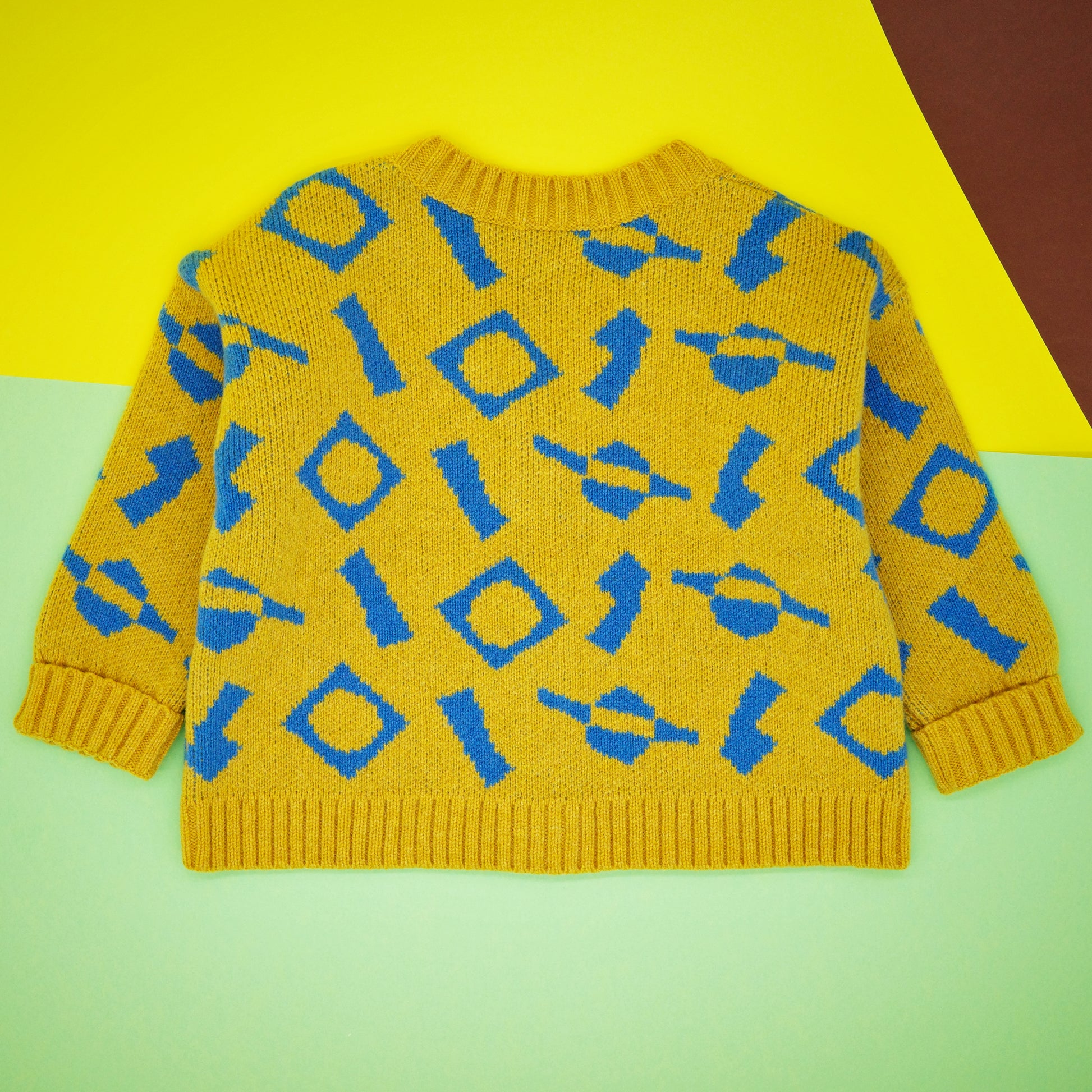 Back of children's wool cardigan, in a blue and yellow jacquard knit.